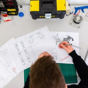 A man is working on a drawing at a desk